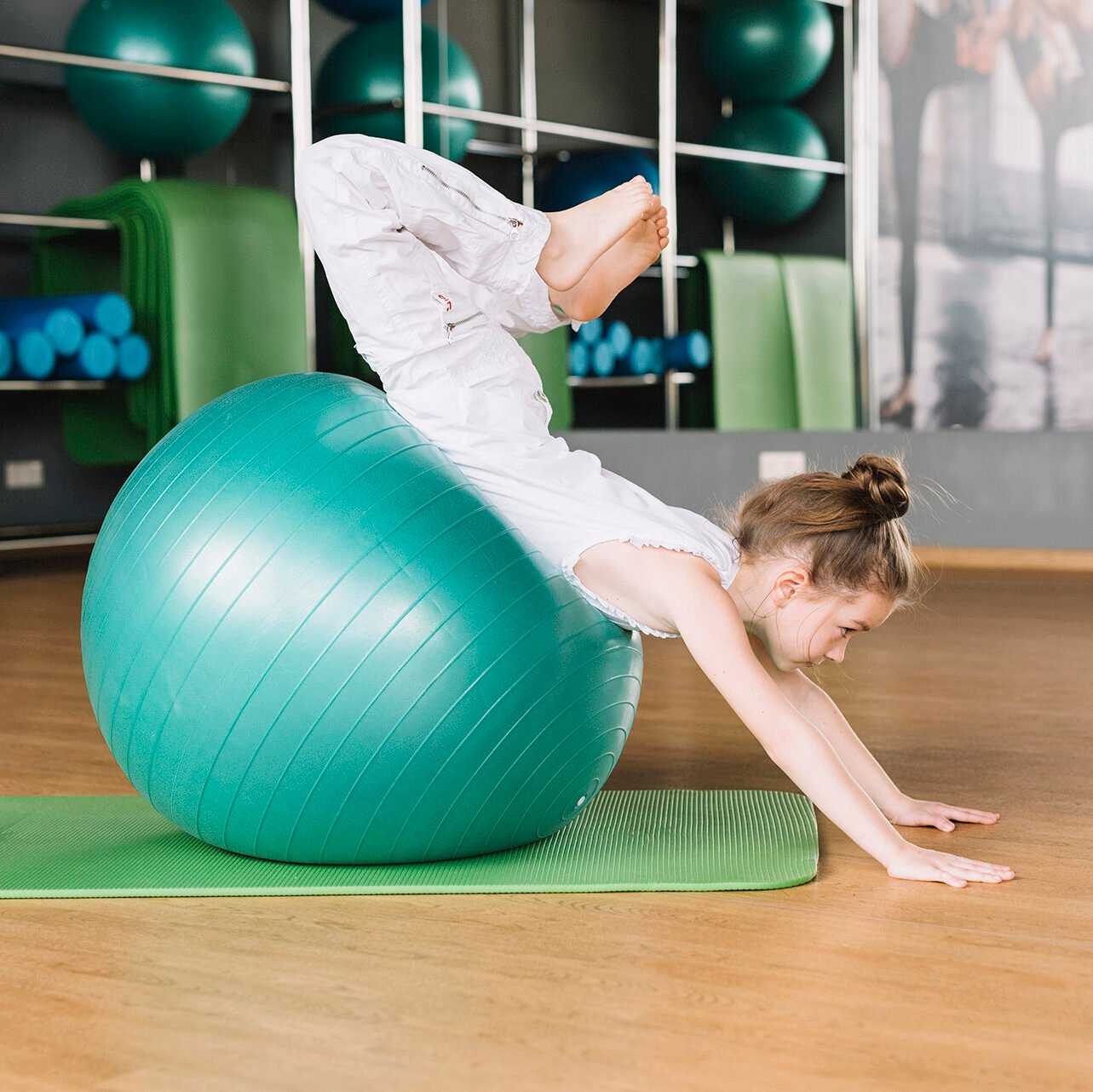 small-girl-doing-exercises-with-exercising-ball-fitness-gym