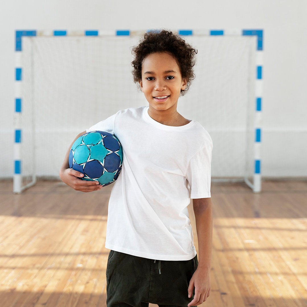 medium-shot-smiley-kid-holding-ball