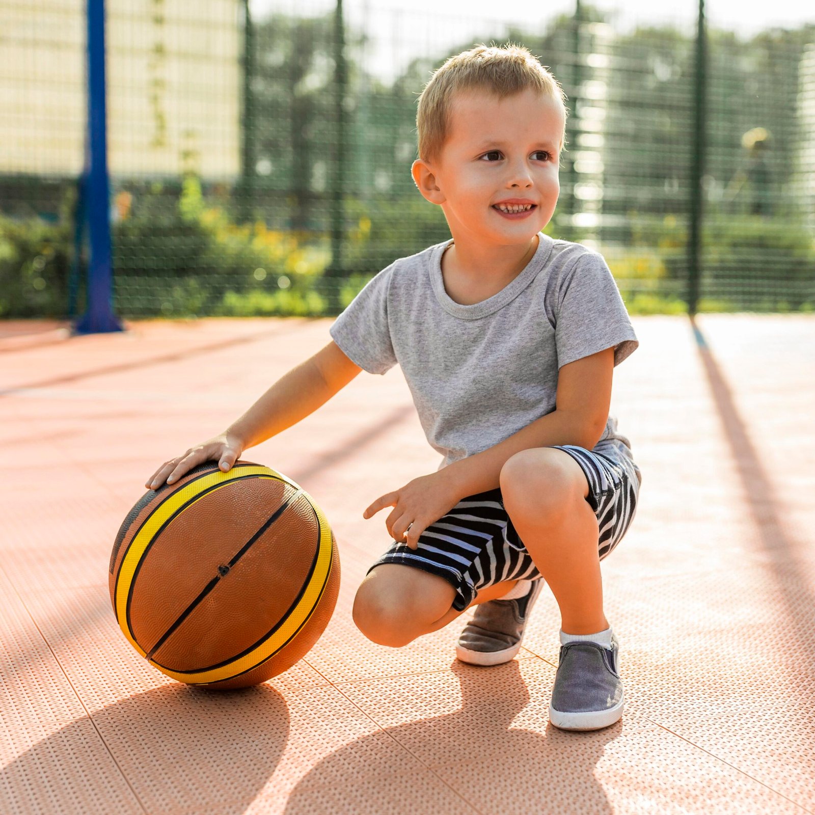 happy-boy-playing-basketball-outdoors